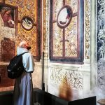 Un fraile observando los frescos de San Giovenale.