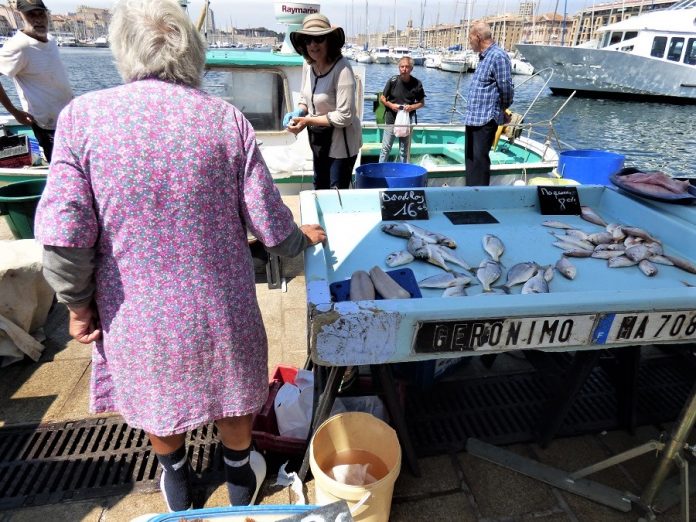 Una anciana vendedora de pescado en Marsella. La mujer trabaja más y cobra menos que el hombre. J.M. PAGADOR