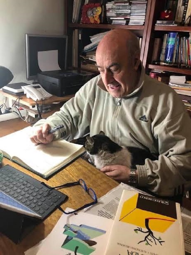Juan Serna, trabajando en su despacho, con su gato Jimy.